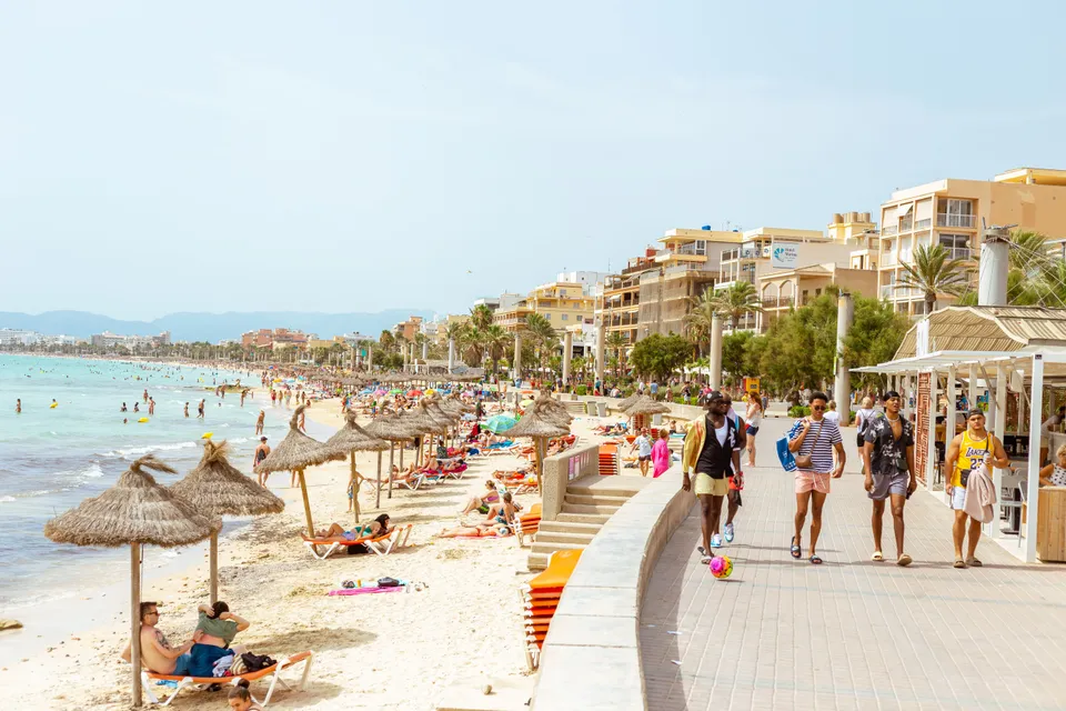 Sunny day at a bustling Ibiza beach with people enjoying leisure activities. Ideal for vacation and tourism content.