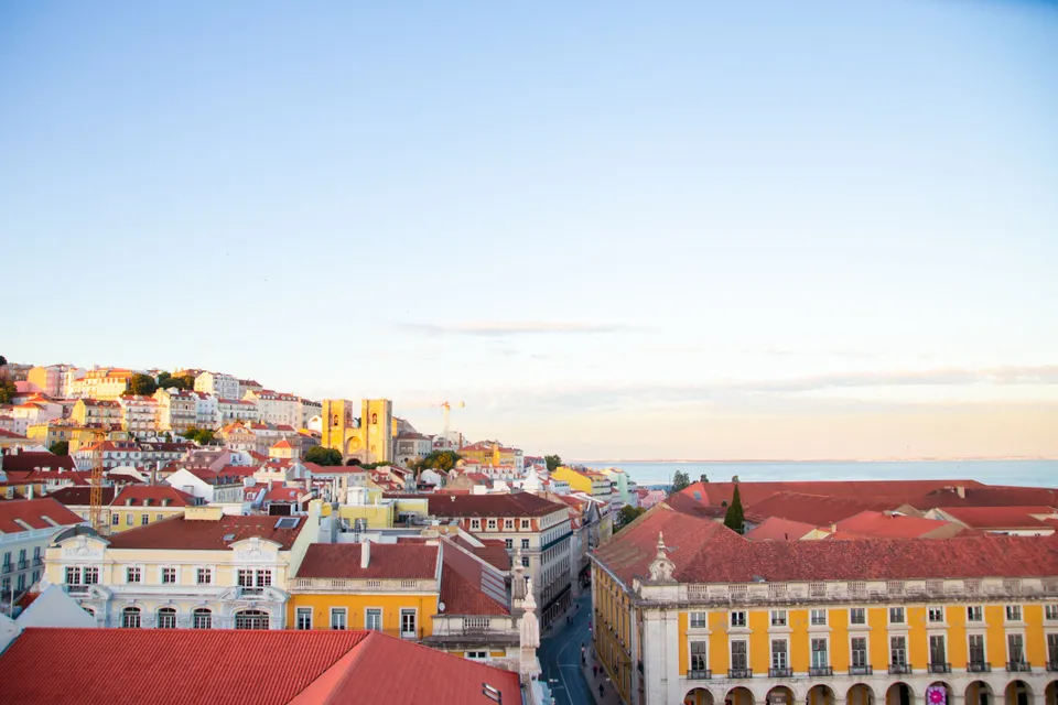 Scenery of modern residential district houses roofs located in Lisbon in early evening under clear blue sky