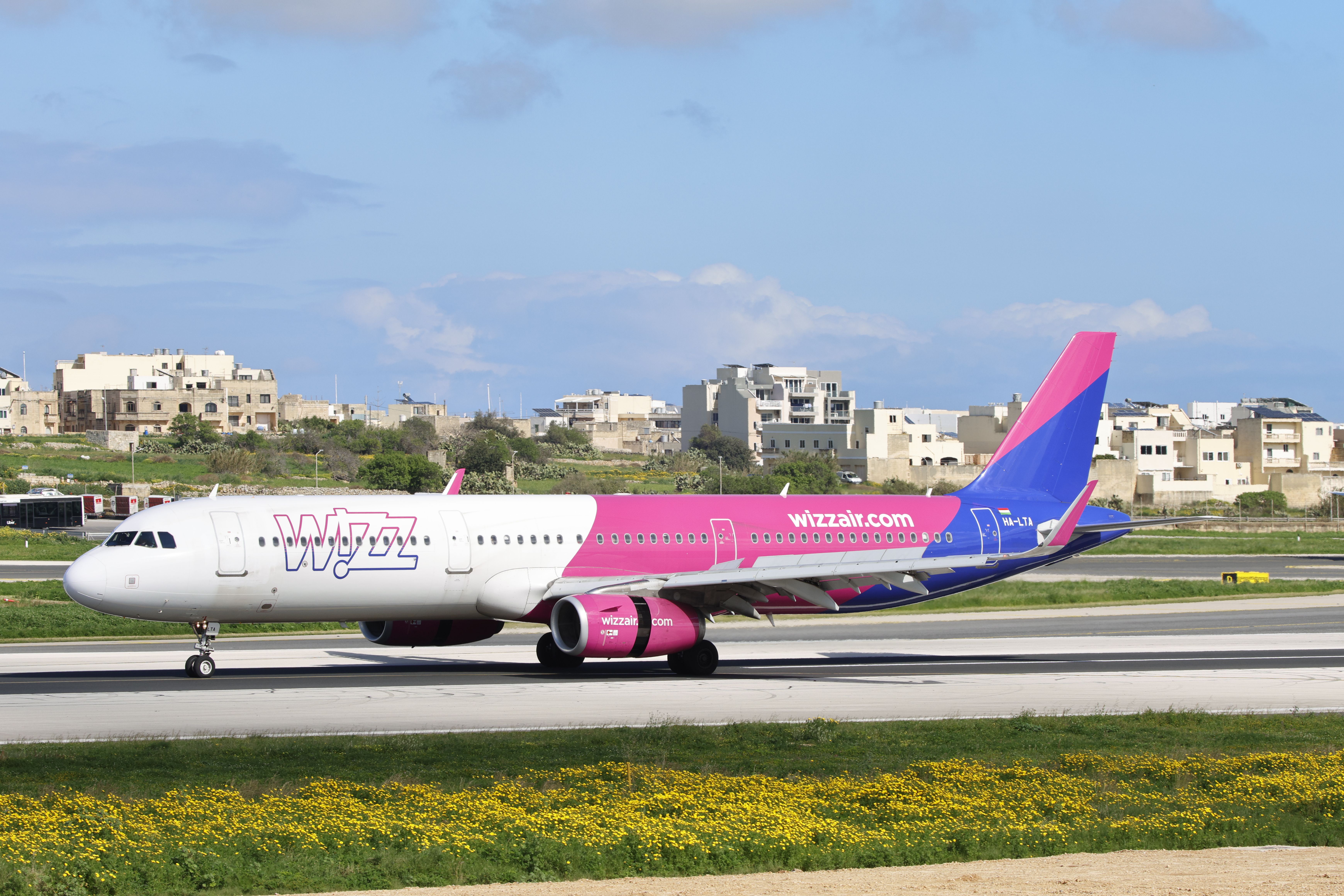 Vibrant aircraft on airport runway with clear skies.