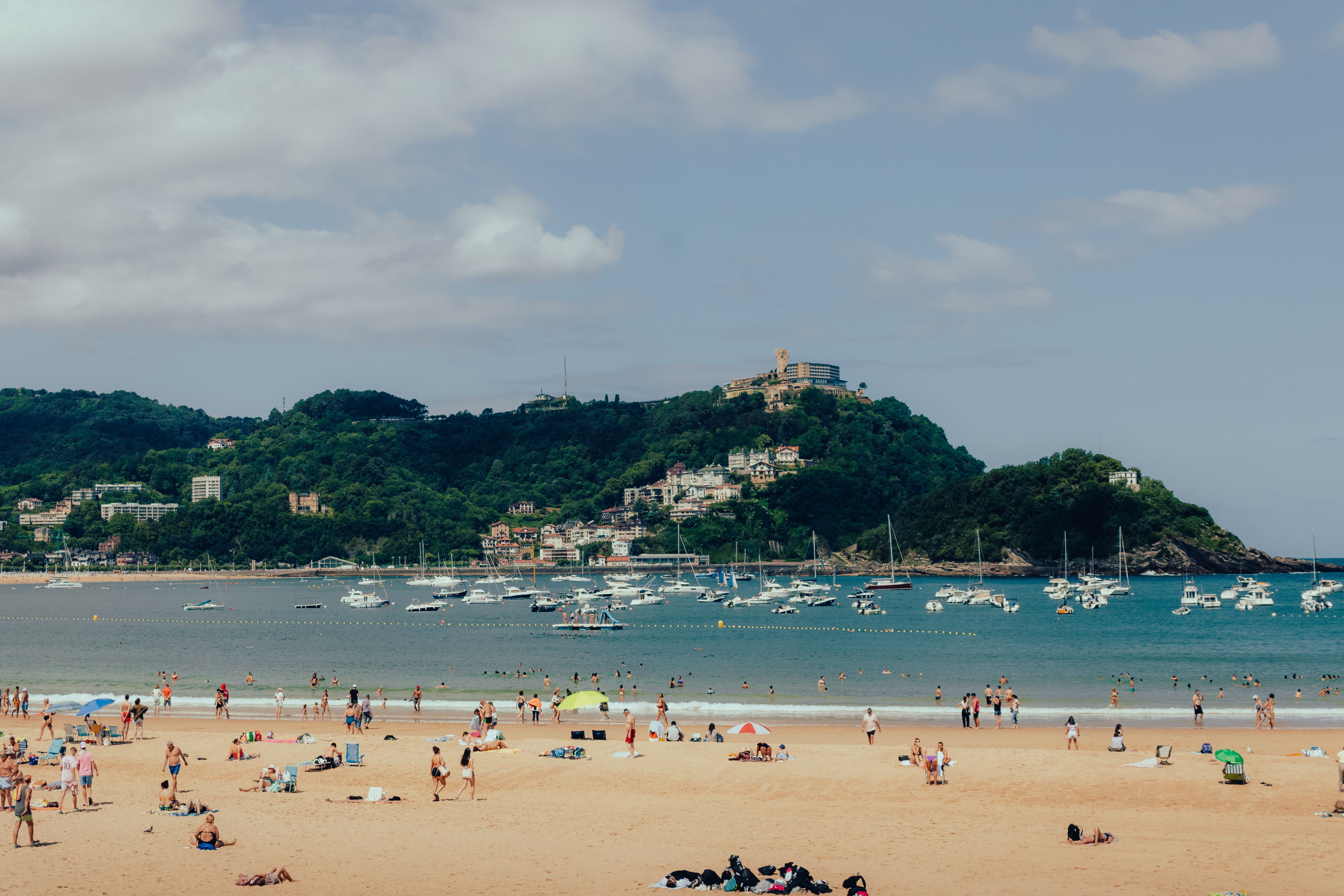 Crowded La Concha Beach in San Sebastián with scenic views and vibrant atmosphere.